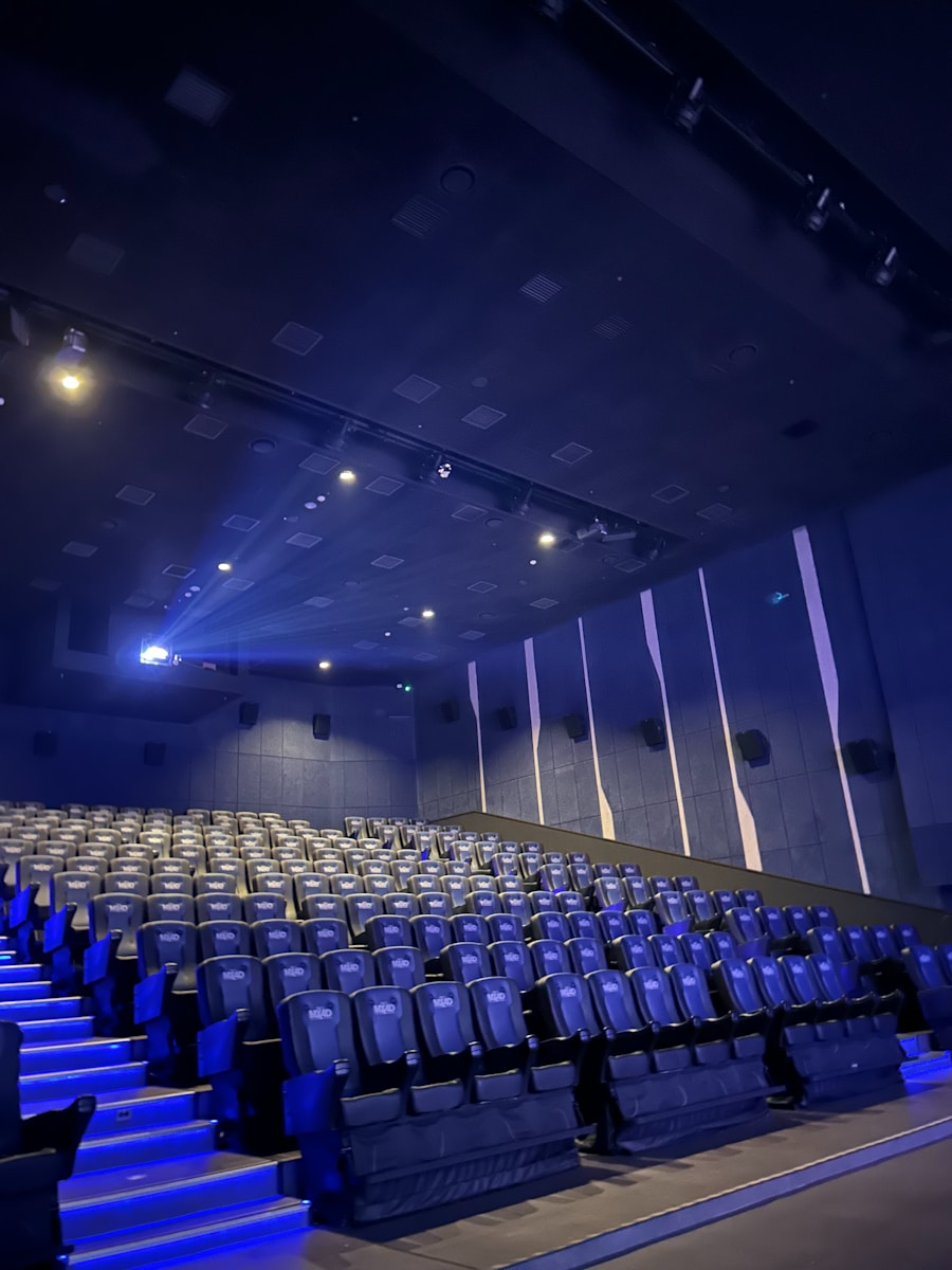 A large auditorium with rows of blue seats